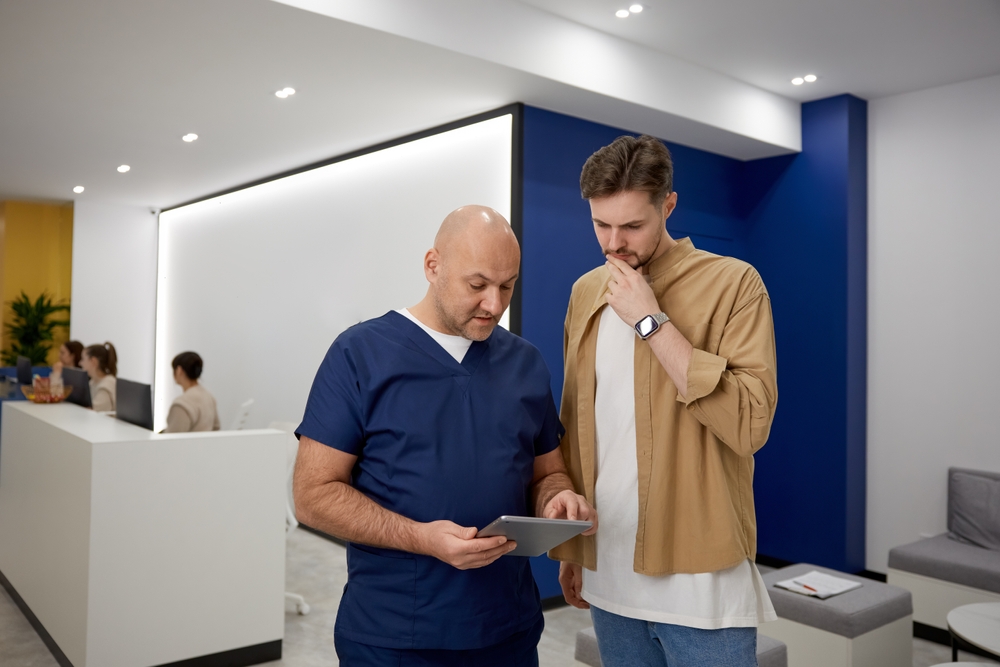 Doctor discussing medical information with a patient in a clinic lobby, highlighting questions like does failure to warn about side effects count as medical malpractice.