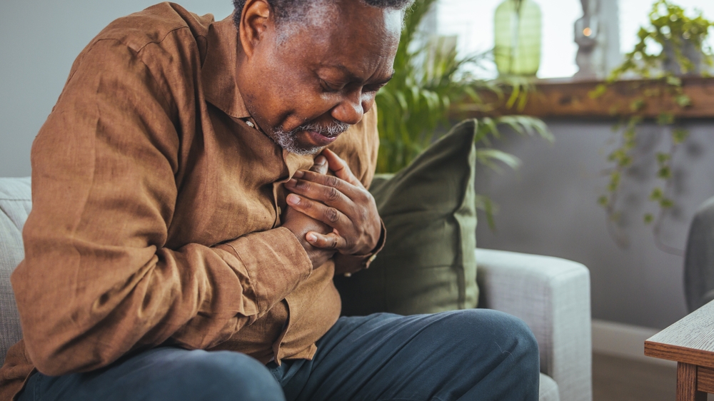 Man experiencing chest pain at home after hospital ignored heart attack symptoms