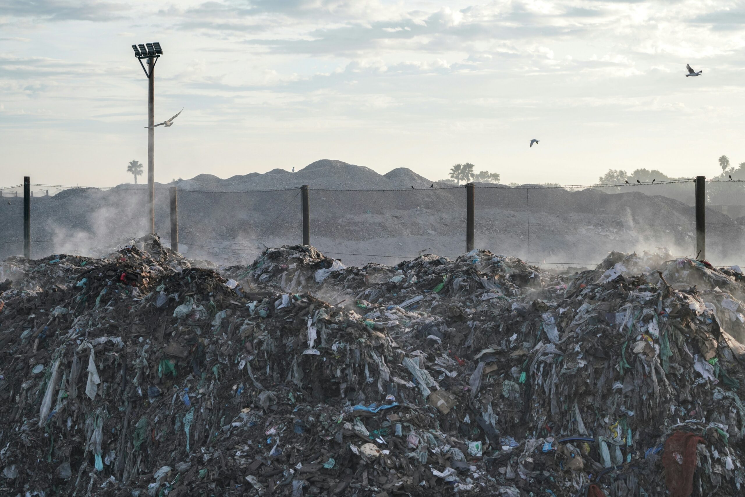 Smoldering waste piles at a shuttered landfill symbolizing the contamination a Keyport landfill cancer lawyer investigates near the Aeromarine site.