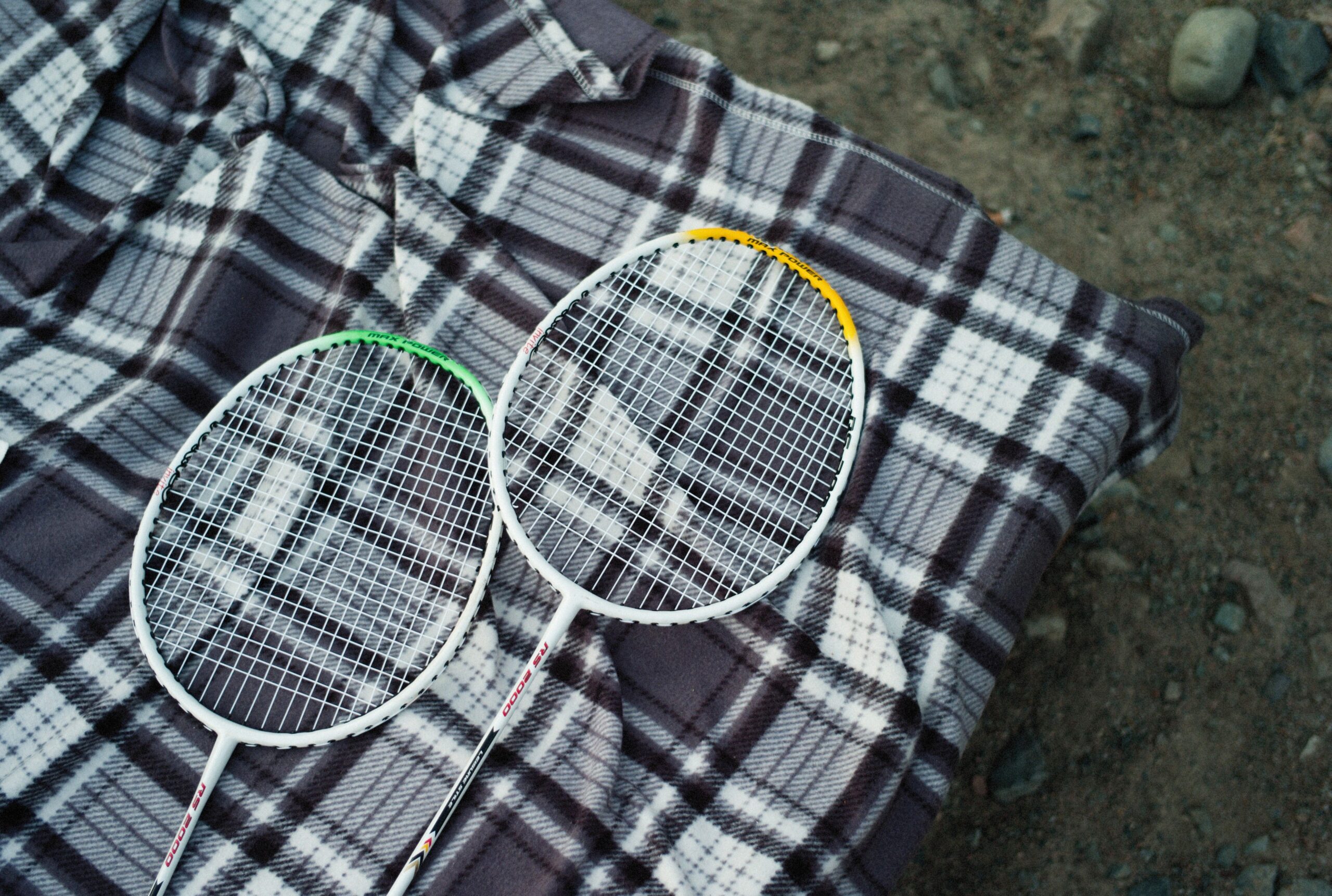 Two badminton rackets resting on a gray plaid blanket, illustrating a New Jersey product liability wrongful death claim.